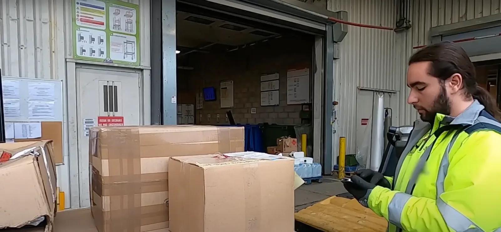 Loan, équipier logistique dans un magasin de Bricolage regarde son téléphone