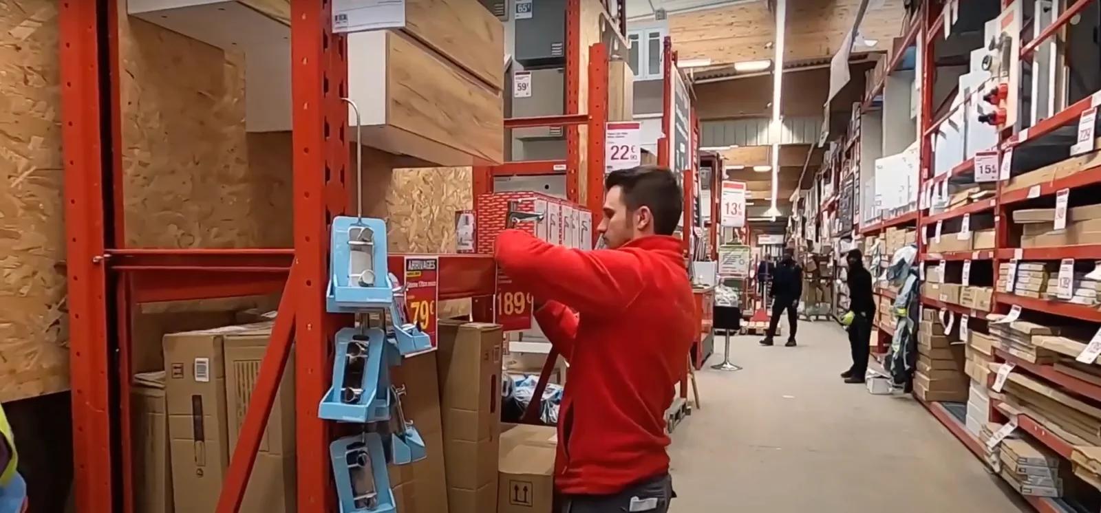 Théo, responsable de rayon sanitaire dans un magasin de Bricolage met à jour des étiquettes de prix